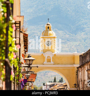 Antigua Guatemala, klassische Kolonialstadt mit berühmten Arco de Santa Catalina und Volcan de Agua hinter Stockfoto