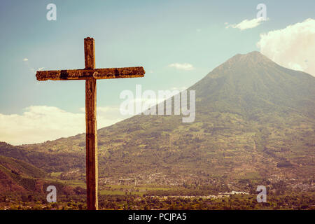 Großes Kreuz steht vor einem Vulkan in Antigua, Guatemala Stockfoto