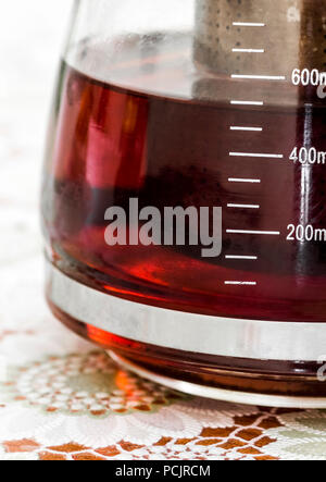 Ein Glas Teekanne mit Tee Blätter steht auf dem Küchentisch. Stockfoto