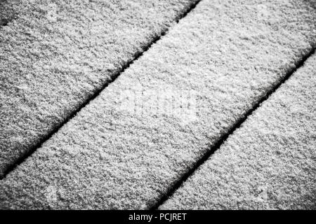 Frischer Schnee deckt den Holzboden auf die Terrasse. Stockfoto
