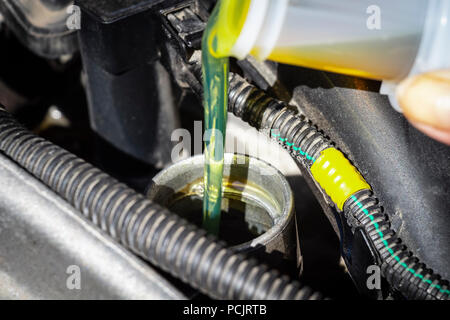 Füllen Sie das Motoröl in den Motor aus dem Gehäuse. Stockfoto