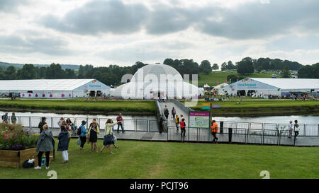 Leute an der RHS Chatsworth Flower Show Wandern & Kreuzung temporäre River Bridge, die zu großen festzelten im ländlichen Showground - Derbyshire, England, Großbritannien Stockfoto