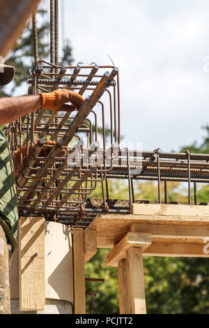 Der Arbeitnehmer Beziehungen stahl Verstärkung mit Kabel der Stiftung zu stärken. Close-up. Tageslicht. Stockfoto