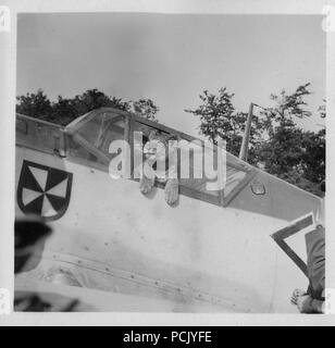 Bild von einem Fotoalbum im Zusammenhang mit der II. Gruppe Jagdgeschwader 3: 'Simba', der Lion cub Maskottchen von II. Gruppe Jagdgeschwader 3, stellt im Cockpit der Messerschmitt Bf 109 E von Oberleutnant Franz von Werra (Adjutant des II./JG 3). Die Gruppe Abzeichen ist deutlich sichtbar auf dem Rumpf des Flugzeugs, direkt vor dem Cockpit. Stockfoto