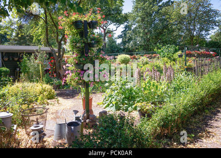 Zaandam, Niederlande, 2. Juli 2018: Pole mit Töpfen mit Geranien in einem Garten in den Niederlanden gefüllt eingerichtet Stockfoto