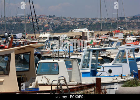 Fischerboote und entspannende Boote an der 'Marina di Procida', die kommerziellen Hafen in Procida, Italien, mit dem italienischen Festland im Hintergrund Stockfoto