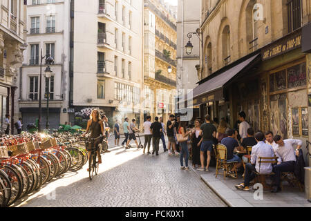 2. Arrondissement von Paris Street Scene - Frau Radfahren durch die cafe Cordonerie auf der Rue Greneta am späten Nachmittag, Frankreich, Europa. Stockfoto