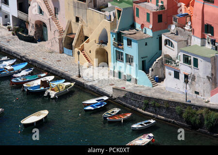 Fischerboote und der Promenade in Corricella auf Procida, Italien, mit den lebhaft bunten Häuser in verschiedenen Pastelltönen lackiert Stockfoto