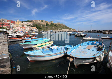 Fischerboote und der Promenade in Corricella auf Procida, Italien, mit den lebhaft bunten Häuser in verschiedenen Pastelltönen lackiert Stockfoto