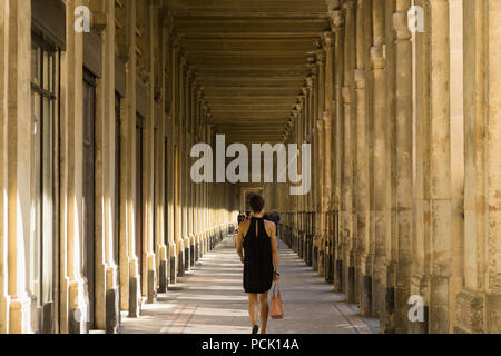 Palais Royal Paris - die Frau, die zu Fuß entlang der Galerie de Beaujolais im Palais Royal in Paris, Frankreich, Europa. Stockfoto
