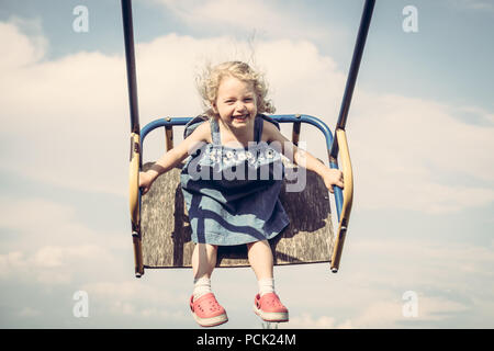 Happy fröhliches Kind Mädchen Spaß schwingen Himmel glückliche unbeschwerte Kindheit Stockfoto