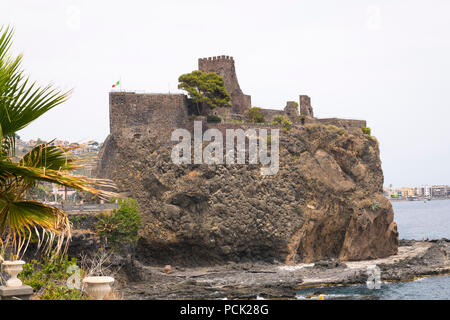 Italien Sizilien Catania Aci Castello Burg Ruinen auf Basalt in 1076 von lava Defensive fort Bastion italienische Flagge halbmast Palme gebaut Stockfoto