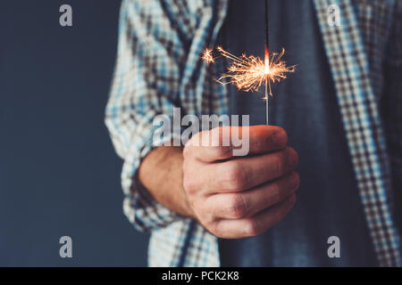 Mann mit Stick Wunderkerze, Nahaufnahme einer Hand, Stockfoto