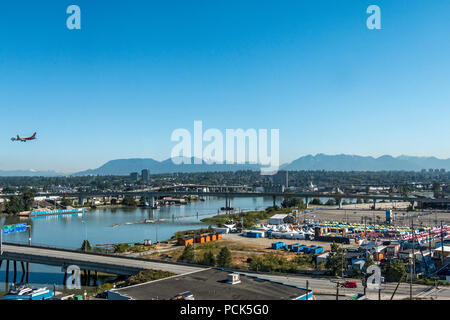 Jet kommt für eine Landung auf dem Internationalen Flughafen von Vancouver, die über das Richmond Night Market. Richmond, BC, Kanada. Fraser River ist auf der linken Seite. Der Markt ist geöffnet an Wochenenden und Feiertagen montags im Sommer. Stockfoto