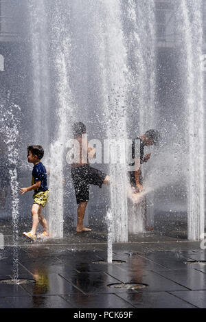 Kinder Abkühlung in Wasser Brunnen in der Rue Jeanne Mance in Montreals Entertainment District. Während der Hitzewelle 2108 genommen. Stockfoto