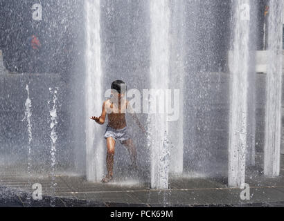 Kinder Abkühlung in Wasser Brunnen in der Rue Jeanne Mance in Montreals Entertainment District. Während der Hitzewelle 2108 genommen. Stockfoto