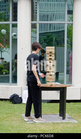 Ein Teenager spielen Riesen Jenga außerhalb des Jeux Loto Quebec Games Festival in Montreal Stockfoto