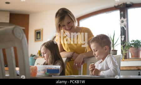 Mutter Kinder helfen bei den Hausaufgaben in der Küche Stockfoto