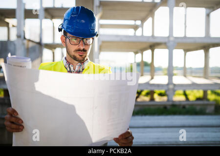 Bau Ingenieur in der hardhat mit Projekt in den Händen Stockfoto