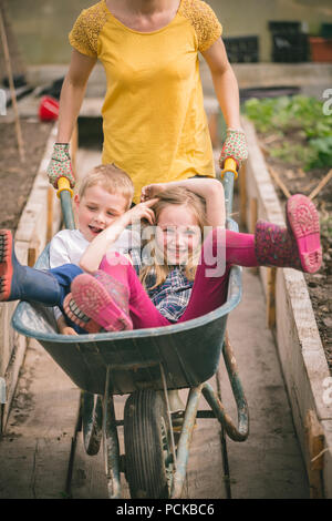 Mutter Spaß mit Zicklein in der Schubkarre Stockfoto