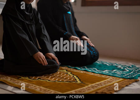 Muslimische Mutter und Tochter Salah zu Hause beten Stockfoto