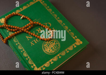 Gebet Perlen auf heiligen Quran gehalten Stockfoto