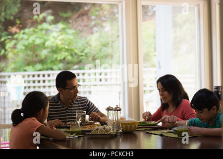 Familie mit Frühstück am Esstisch Stockfoto