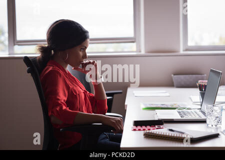 Geschäftsfrau, die Arbeiten am Laptop im Büro Stockfoto