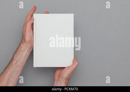Männliche Hand ein geschlossenes Buch zeigt das Buch. Buchen Sie Mock up Vorlage. Stockfoto