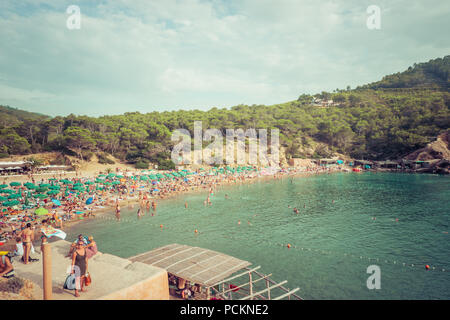 Ibiza, Spanien, 27. August 2017: Ibiza Naturstrand mit Blick auf einige Touristen im Sommer. Stockfoto