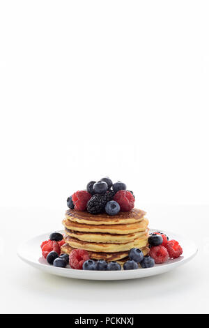 Stapel Pfannkuchen mit frischen Heidelbeeren, Himbeeren und Blackberry auf weiße Platte Stockfoto