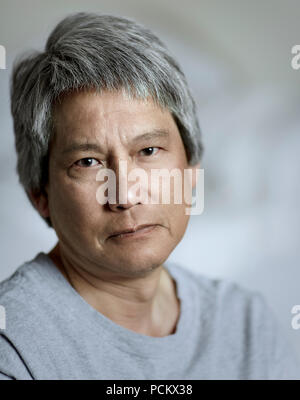 Porträt eines chinesischen Mann mit Grau, lächelnd mit geringer Tiefenschärfe Stockfoto