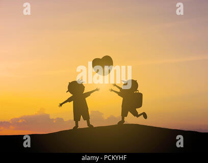 Silhouette Kinder spielen herzförmige Luftballons mit Sonnenuntergang Stockfoto