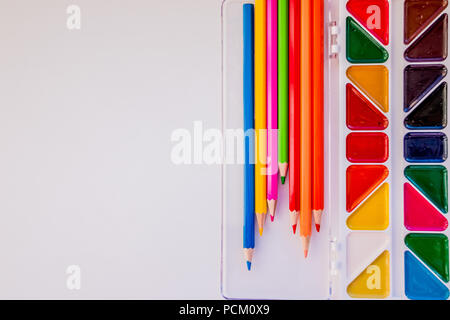 Für Text, Design statt. Der Arbeitsbereich des Künstlers für die Zeichnung. Buntstifte, Aquarell, Farben, Pinsel, Skizzenbuch, weißes Papier isoliert auf backgroun Stockfoto