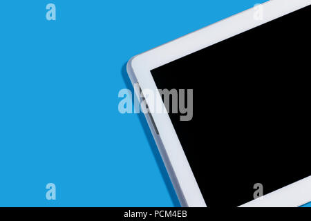 Neue moderne weiße Tablet-PC liegen auf einem blauen Hintergrund mit einem ausgeschaltet. Konzept von Gadgets. freier Platz für Werbung text Stockfoto