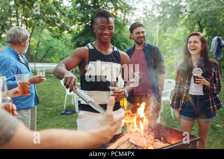 Eine Gruppe von Freunden, Grill im Hof. Konzept über gute und positive Stimmung mit Freunden Stockfoto