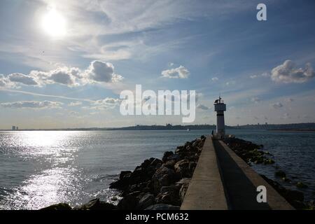 Leute um kadiköy Leuchtturm hängen an einem sonnigen Tag und das Stadtbild im Hintergrund Stockfoto