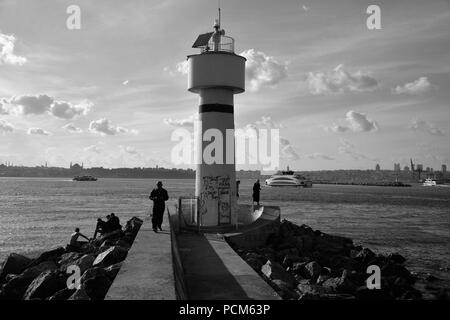 Leute um kadiköy Leuchtturm hängen an einem sonnigen Tag und das Stadtbild im Hintergrund Stockfoto