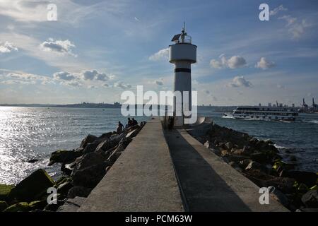 Leute um kadiköy Leuchtturm hängen an einem sonnigen Tag und das Stadtbild im Hintergrund Stockfoto