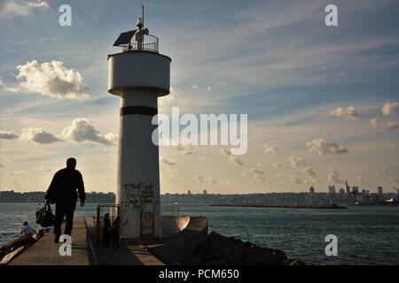 Leute um kadiköy Leuchtturm hängen an einem sonnigen Tag und das Stadtbild im Hintergrund Stockfoto