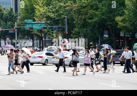 Seoul, Südkorea. 3 Aug, 2018. Menschen Überqueren einer Straße mit Sonnenschirmen an einem heissen Sommertag in Seoul, Südkorea, Aug 3, 2018. Credit: Wang Jingqiang/Xinhua/Alamy leben Nachrichten Stockfoto