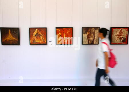 (180803) - Qingdao, August 3, 2018 (Xinhua) - ein Besucher Kunstwerke in der Ausstellung der ausgezeichneten Arbeiten von Lehrern und Schülern von Sichuan Fine Arts Institute geschaffen, und in dem jimo Bezirk von Qingdao, einer Küstenstadt in der ostchinesischen Provinz Shandong, Aug 3, 2018. Die 10-tägige Ausstellung, an der Dexin Art Center am 12.08.3 geöffnet, angezeigt, fast 500 Kunstwerke, darunter traditionelle chinesische Malerei, Öl Gemälde, Drucke und Skulpturen. (Xinhua / Liang Xiaopeng) Stockfoto