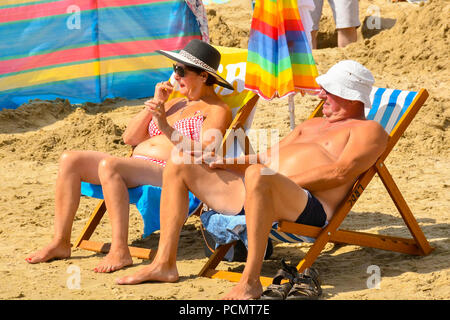 Lyme Regis, Dorset, Großbritannien. 3. August 2018. UK Wetter. Sonnenanbeter am Strand an der Küste von Lyme Regis in Dorset genießen die warme Sonne und strahlend blauen Himmel während der Sommerferien. Foto: Graham Jagd-/Alamy leben Nachrichten Stockfoto