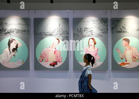 (180803) - Qingdao, August 3, 2018 (Xinhua) - ein kleines Mädchen views Kunstwerke in der Ausstellung der ausgezeichneten Arbeiten von Lehrern und Schülern von Sichuan Fine Arts Institute geschaffen, und in dem jimo Bezirk von Qingdao, einer Küstenstadt in der ostchinesischen Provinz Shandong, Aug 3, 2018. Die 10-tägige Ausstellung, an der Dexin Art Center am 12.08.3 geöffnet, angezeigt, fast 500 Kunstwerke, darunter traditionelle chinesische Malerei, Öl Gemälde, Drucke und Skulpturen. (Xinhua / Liang Xiaopeng) Stockfoto