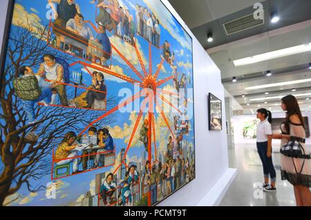 (180803) - Qingdao, August 3, 2018 (Xinhua) - Besucher sehen Kunstwerke in der Ausstellung der ausgezeichneten Arbeiten von Lehrern und Schülern von Sichuan Fine Arts Institute geschaffen, und in dem jimo Bezirk von Qingdao, einer Küstenstadt in der ostchinesischen Provinz Shandong, Aug 3, 2018. Die 10-tägige Ausstellung, an der Dexin Art Center am 12.08.3 geöffnet, angezeigt, fast 500 Kunstwerke, darunter traditionelle chinesische Malerei, Öl Gemälde, Drucke und Skulpturen. (Xinhua / Liang Xiaopeng) Stockfoto