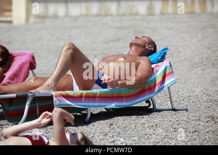 Roquetas de Mar, Almeria, Spanien. August 3nd, 2018. Die Hitzewelle, schlägt Spanien wird erwartet, 45°C in einigen Teilen des Landes zu überschreiten. Roquetas de Mar ist eine kleine touristische Stadt westlich der Hauptstadt Almeria, berühmt für seine Maurische Burg. Nahaufnahme von einem Mann mit geschlossenen Augen liegen auf einer Sonnenliege am Strand. Foto: Paul Lawrenson/Alamy leben Nachrichten Stockfoto