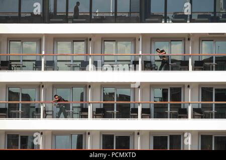 London, 3. August 2018: Reiniger Fenster bei der Arbeit auf dem Kreuzfahrtschiff Viking Sky, bei Greenwich Pier im schönsten Sonnenschein mit Temperaturen in London bis etwa 31 C. ist Credit: Claire Doherty/Alamy leben Nachrichten Stockfoto