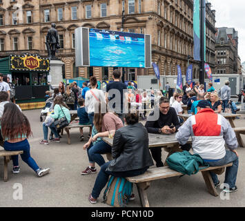 George Square, Glasgow, Schottland. 03. August 2018. Menschen in im Zentrum von Glasgow entspannen und genießen Festival 2018 George Square. Das Festival läuft parallel mit der Europäischen Meisterschaften, Glasgow 2018. George Square ist ein frei Ort mit mehreren Leben und virtuellen Attraktionen täglich. Es gibt einen großen Bildschirm mit Live-Übertragung der sportliche Wettbewerb Aktion. In diesem Foto, Synchronschwimmen gezeigt wird. Credit: Elizabeth Leyden/Alamy leben Nachrichten Stockfoto