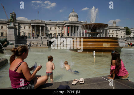 London, Großbritannien. 3 Aug, 2018. Kinder spielen an einem Brunnen am Trafalgar Square in London, Großbritannien, am Aug 3, 2018. Großbritannien ist derzeit hohen Temperaturen als eine Hitzewelle in Europa fort. Quelle: Tim Irland/Xinhua/Alamy leben Nachrichten Stockfoto
