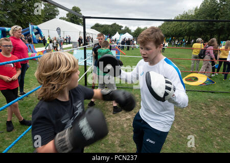 Glasgow Green, Glasgow, Schottland. 03. August 2018. Charlie Flynn, Boxen, Goldmedaillengewinner bei den Commonwealth Games, Glasgow 2014, Coaching ein Junge an einem haben-a Go Sport Schmeckerlernabschnitt bei Go Live! An der Grünen, Teil des Festivals 2018. Das Festival läuft parallel mit der Europäischen Meisterschaften; Glasgow 2018. Glasgow Green ist ein kostenloses Festival Veranstaltungsort mit vielen Attraktionen aus Give-it-a-go Sport, Musik und Kochvorführungen. Credit: Elizabeth Leyden/Alamy leben Nachrichten Stockfoto